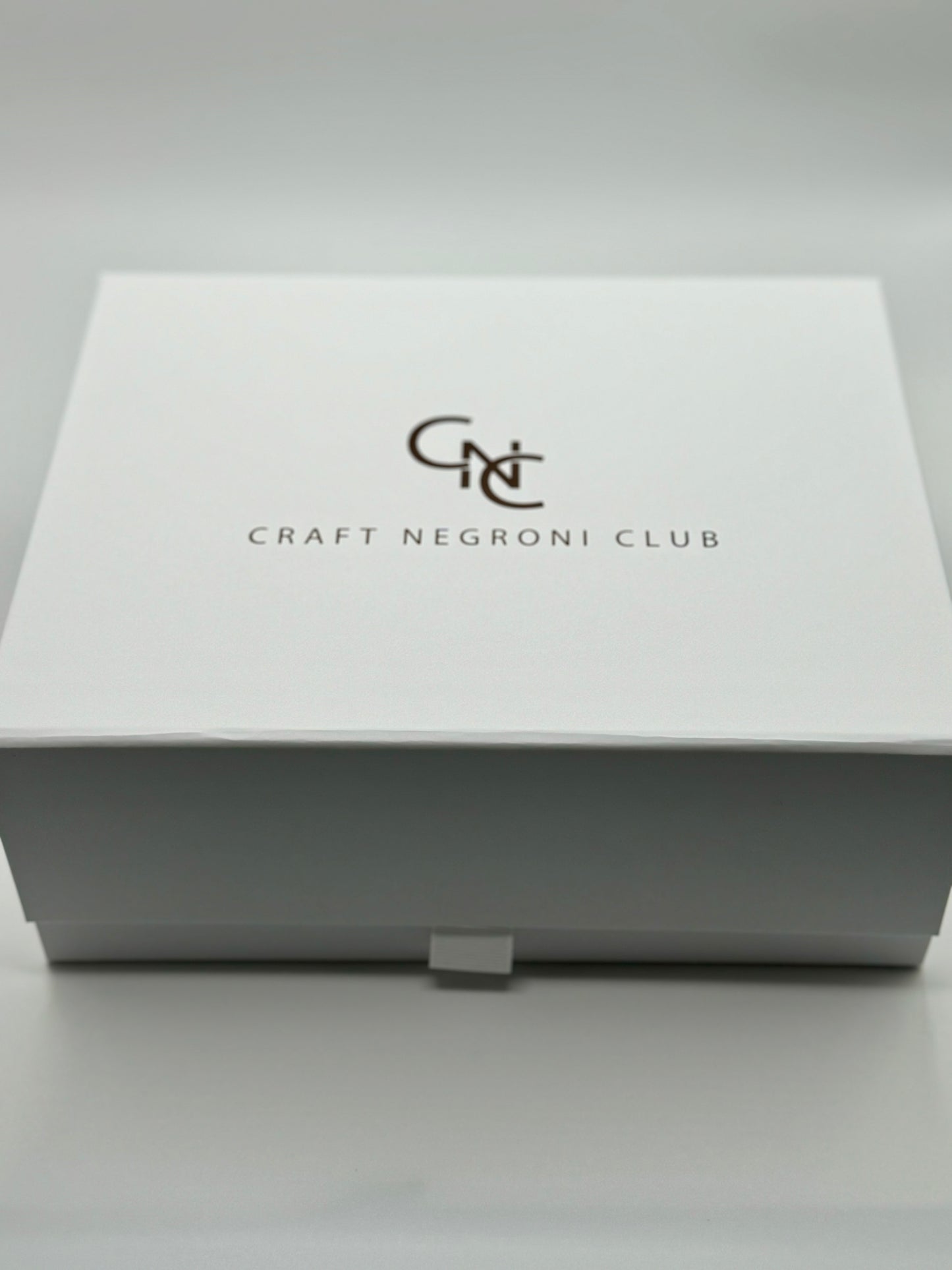 picture of a close white box with metallic bronze writing that reads Craft Negroni Club 