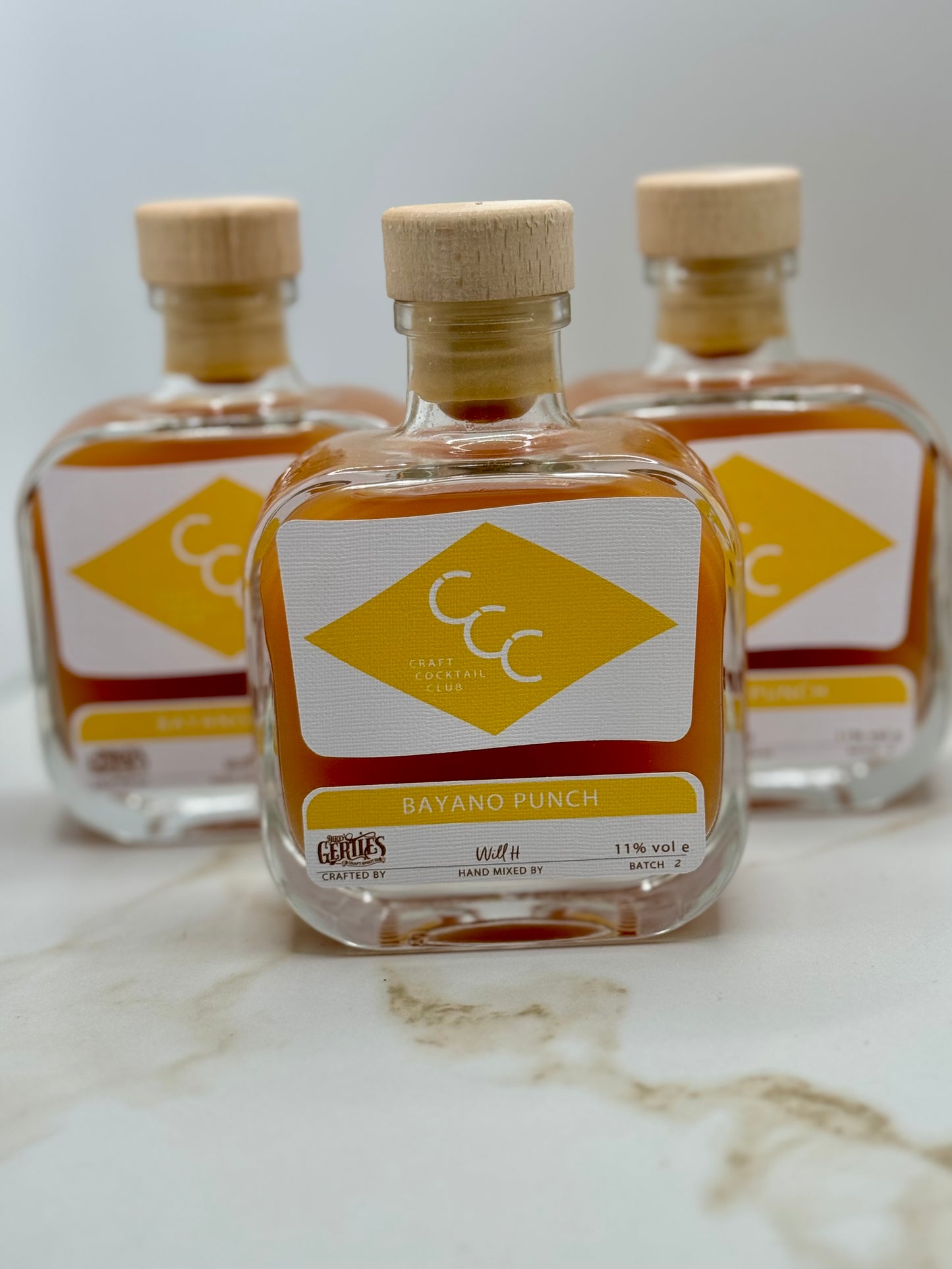 picture of three craft cocktail club bottles together, yellow label reads Bayano punch