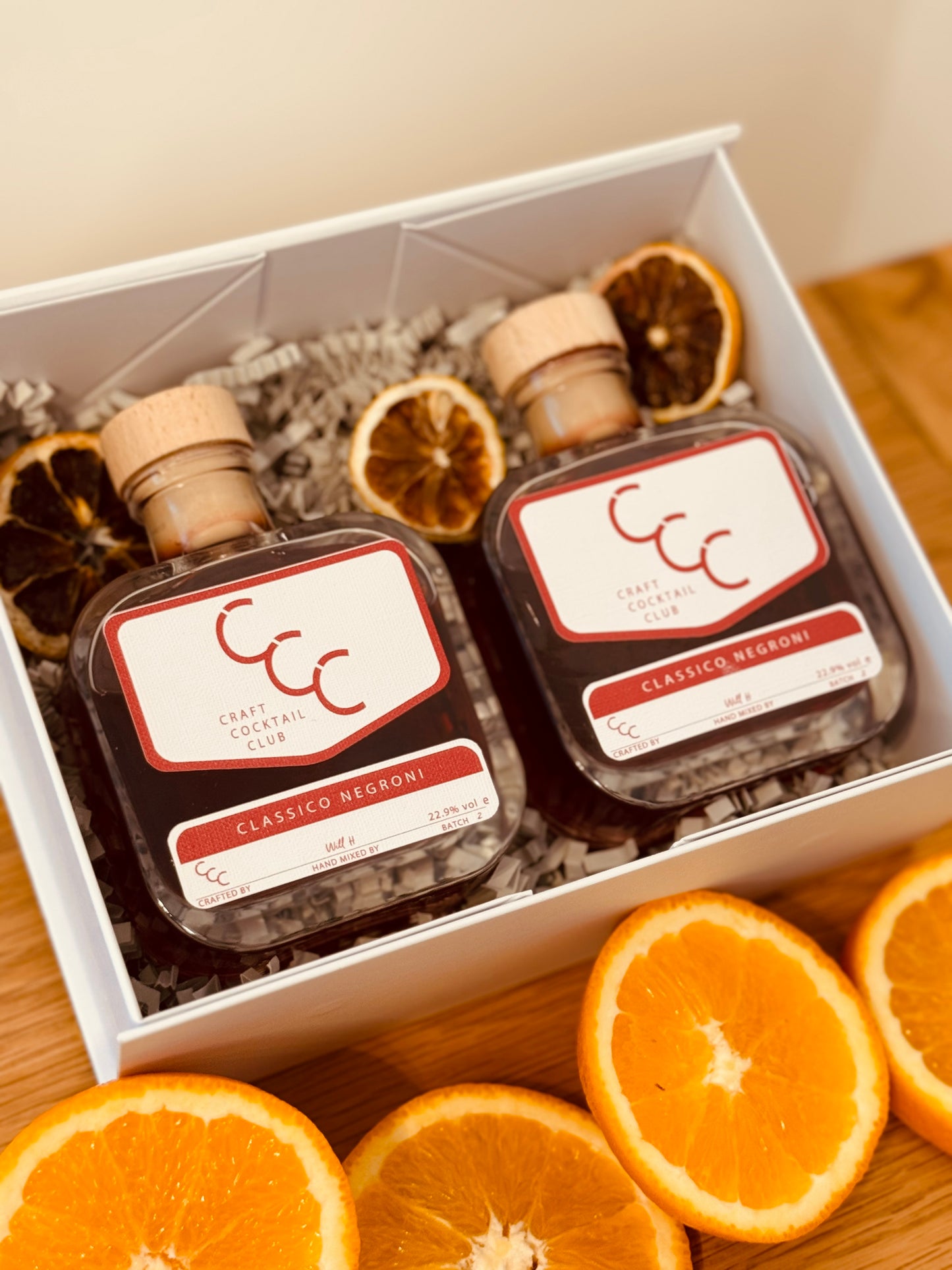 picture of two bottles in a white gift box, the bottles have white labels that say raft Cocktail Club