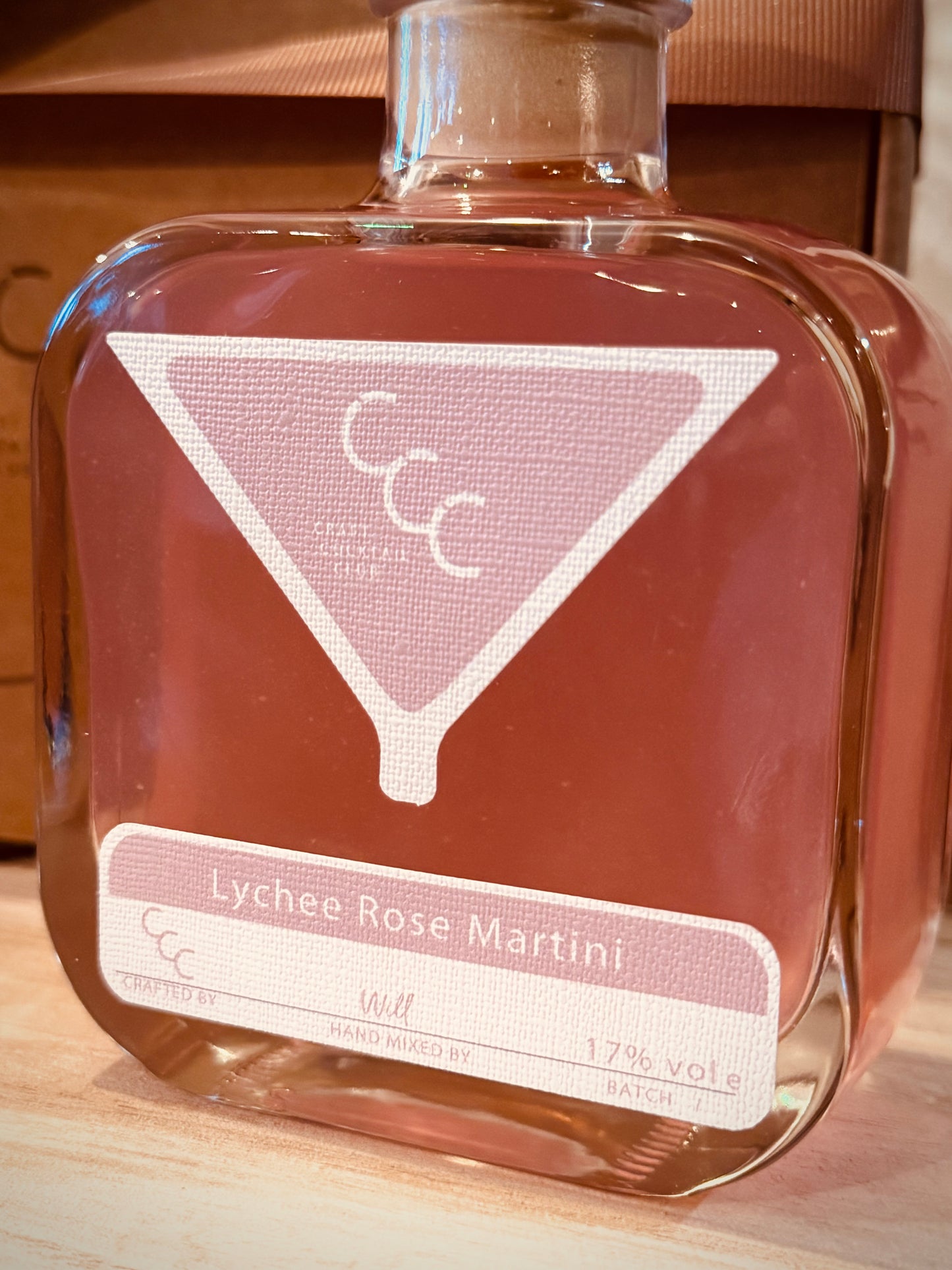 Picture of a small square bottle of Pink pre mixed cocktail  label reads Lychee rose martini 