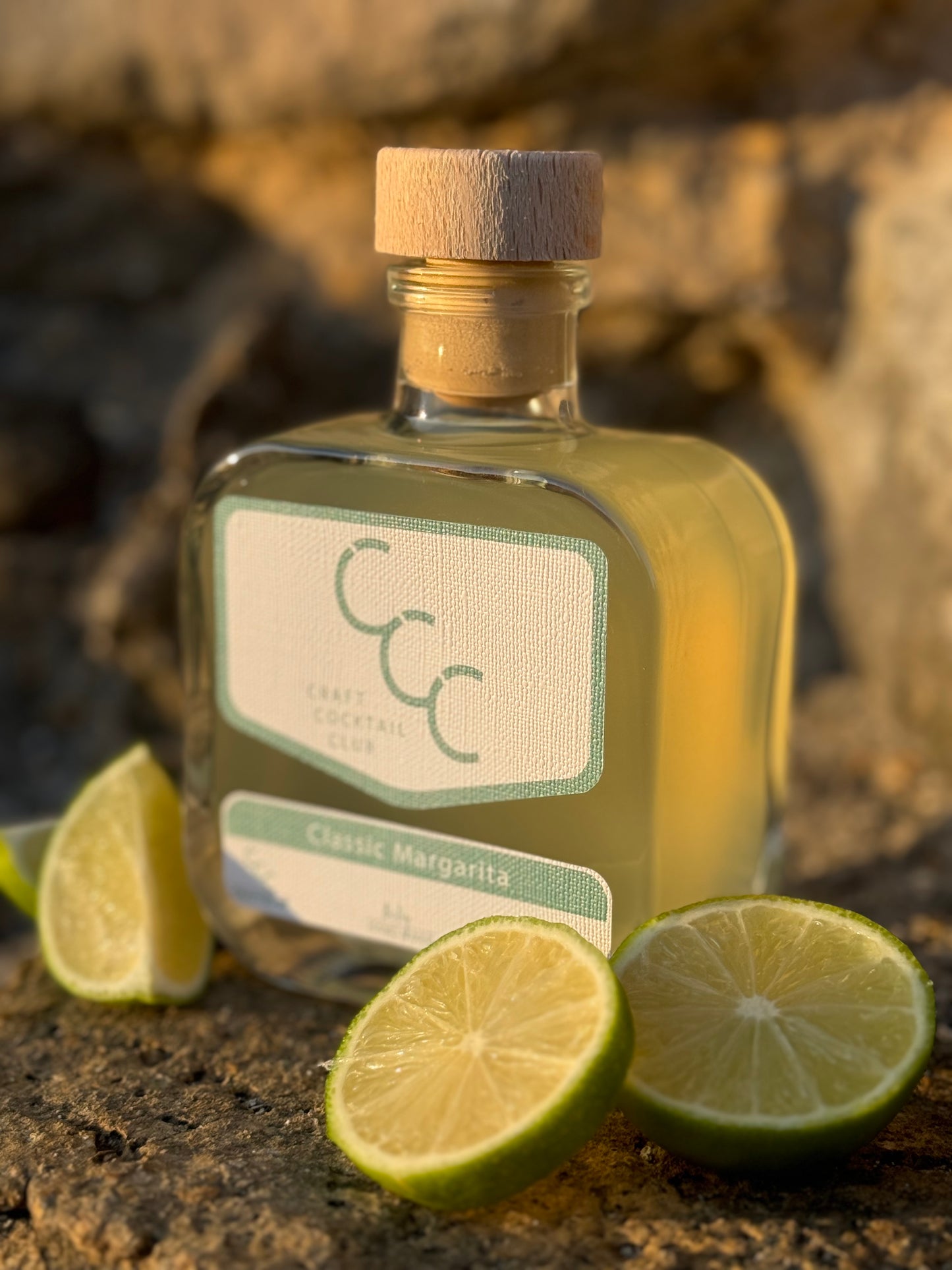 picture of a craft cocktail club bottle with limes at the base