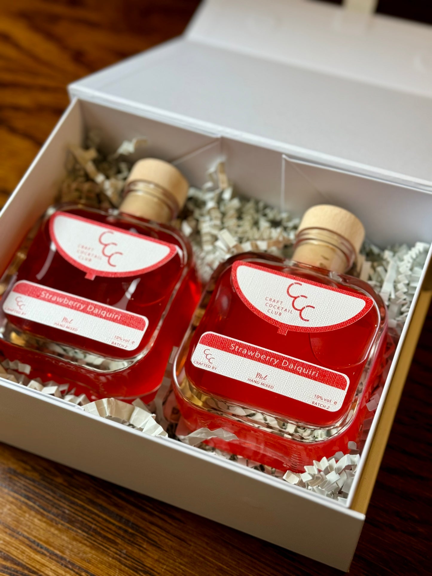 Picture  of a Strawberry daiquiri gift box containing two bottles of ready to drink cocktail on. wooden table 