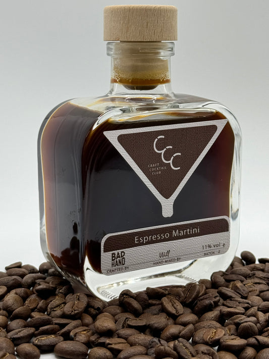 Picture of a ready to drink Cocktail in a square glass bottle surrounded by coffee beans, label reads Espresso Martini