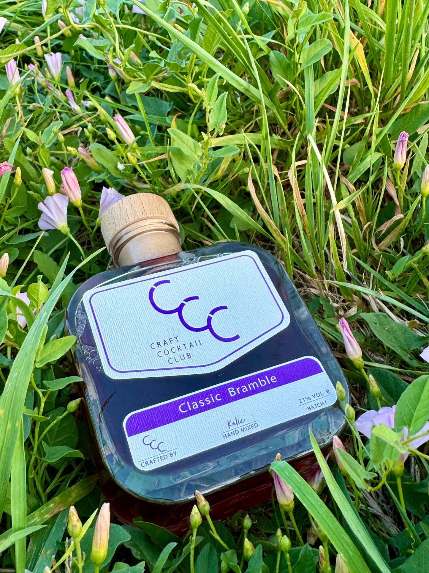 picture of a bottle of ready made bramble cocktail on green grass