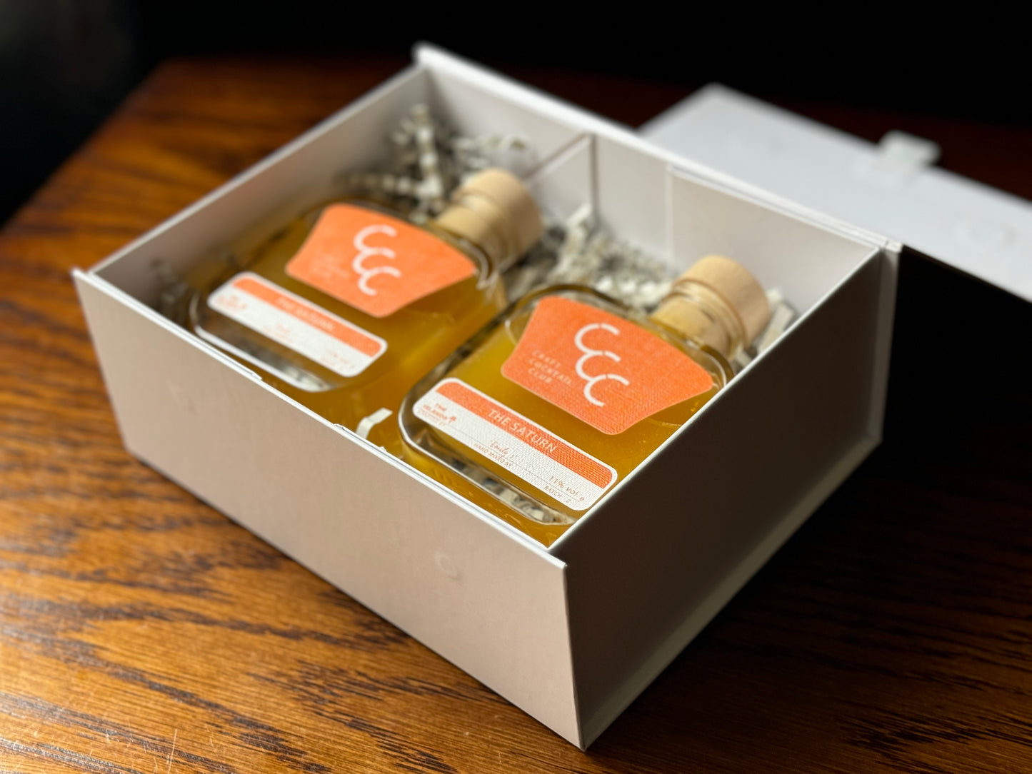 picture of two bottles of mango margaritas in a gift box on a wooden table 