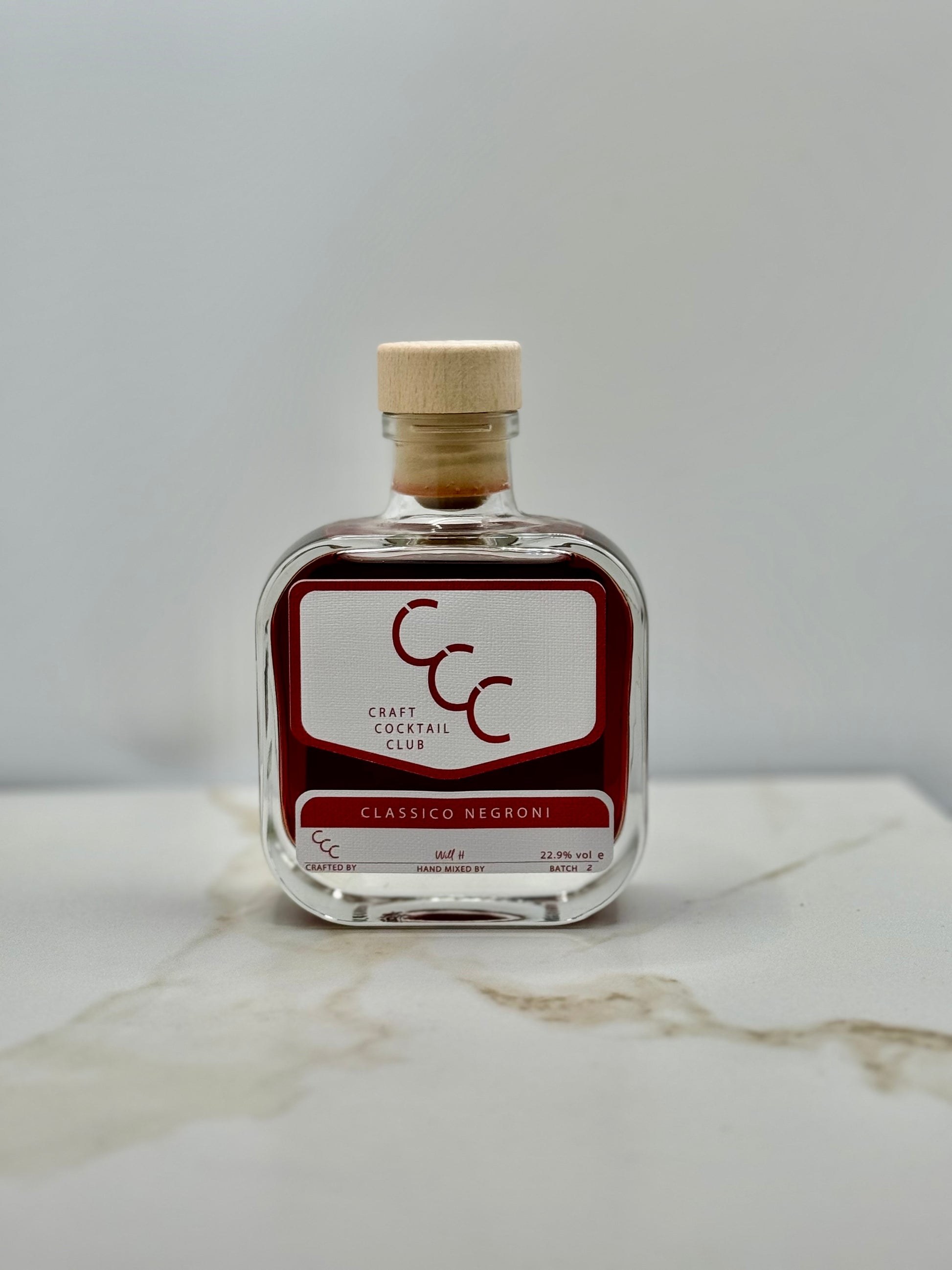 picture of a single bottle of negroni on a cream tile 